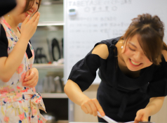 Dlop Cooking Academyの代表「星野春香」が生徒と一緒に笑顔で料理をしている